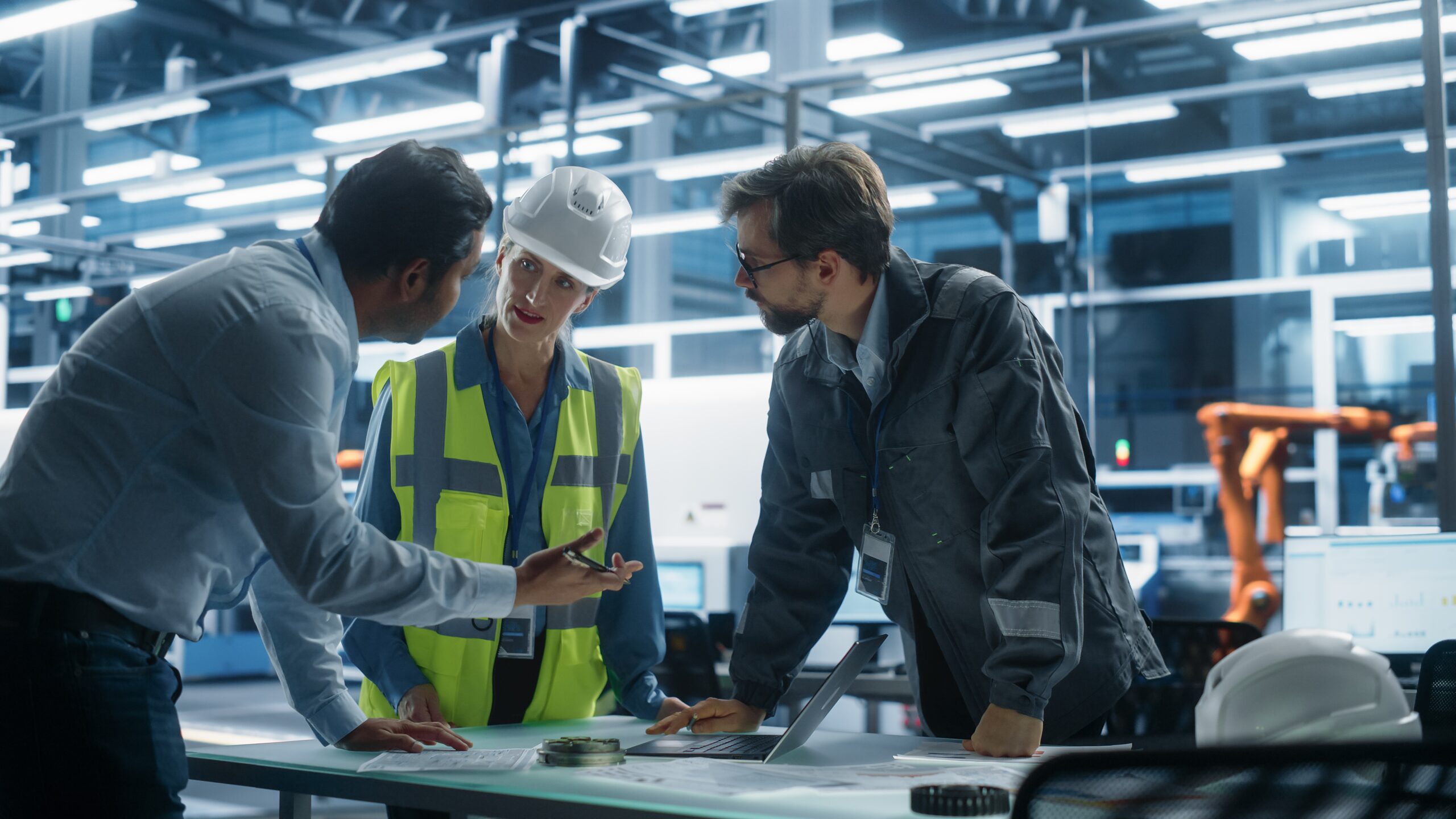 Managers talk to engineer on UK factory floor