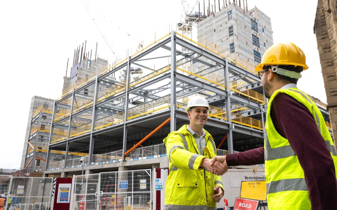 Why Commercial Insurance Has Become a Competitive Advantage for UK Subcontractors Image of two men in hi vis jackets near a property development site. words on the image say: Winning work isn't just about price anymore... it's about being contract ready.